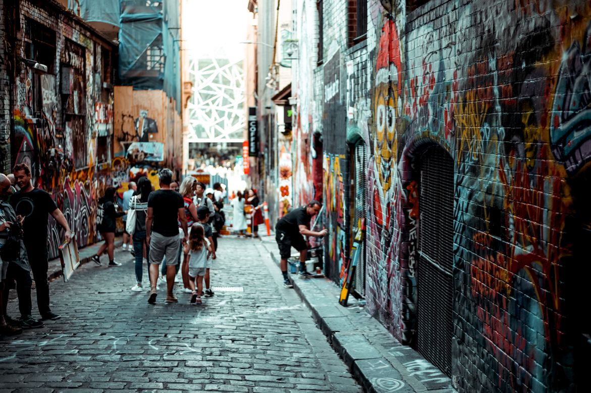 People drawing graffiti on walls in a lane in Melbourbe, Australia.